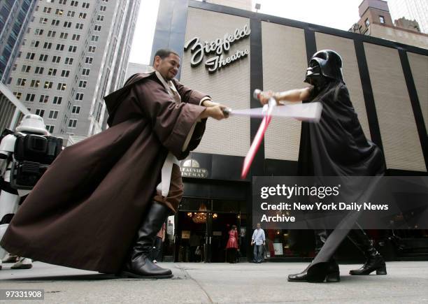 Diehard fans Freddie Crespo Jr. And Sachiko Nahagone battle it out with their light sabers as they wait to see "Star Wars: Episode III - Revenge of...