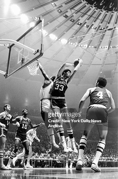 Milwaukee Bucks' Lew Alcindor pulls down a rebound on a missed shot by New York Knicks' Willis Reed.