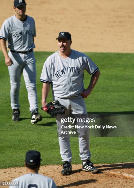 Teammates converge on David Wells as hopes of victory disintegrate in the fifth inning of Game 4 of the 2002 American League Division Series against...