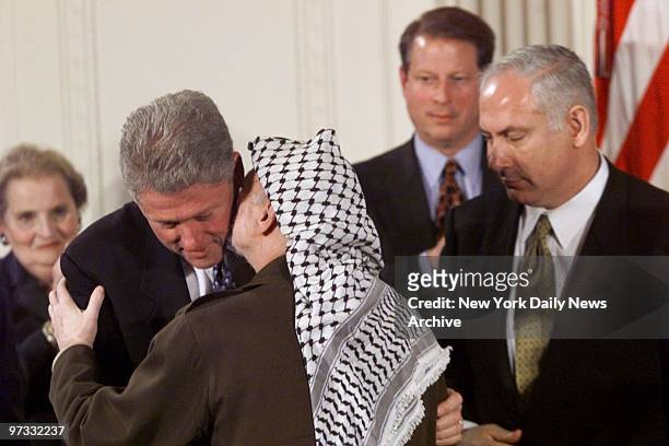 Palestinian leader Yasser Arafat kisses President Bill Clinton while Israeli Prime Minister Benjamin Netanyahu, Vice President Al Gore and Secretary...