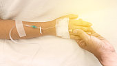 patients on the bed have injecition saline show hand and arm