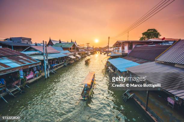 boat floating along amphawa riverside market, bangkok, thailand. - bangkok skyline stock pictures, royalty-free photos & images