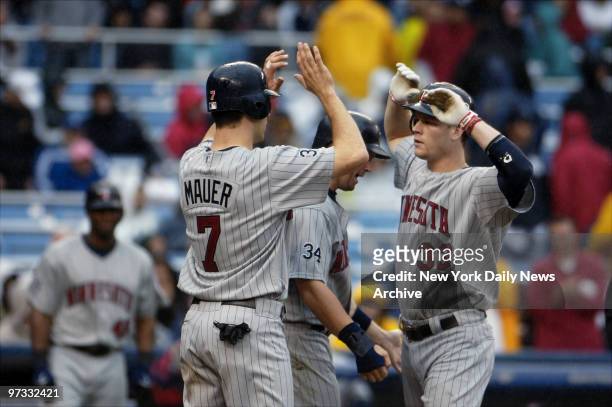 Minnesota Twins' Justin Morneau celebrates his three-run homer with teammates Joe Mauer and Michael Cuddyer in the eighth inning against the New York...