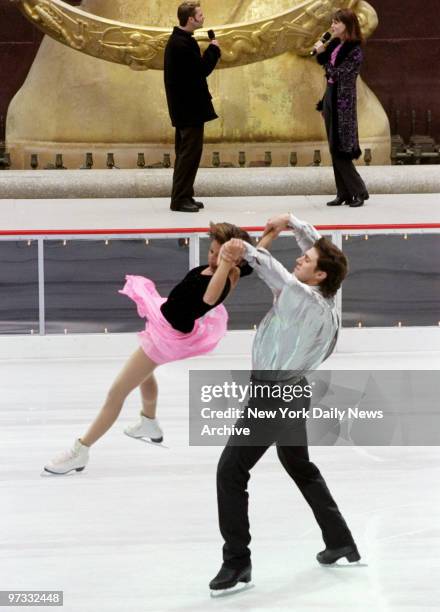 Oksana Kazakova and Artur Dmitriev perform on the ice while cast members from the play "Footloose" sing a song as the ice skating rink at Rockefeller...