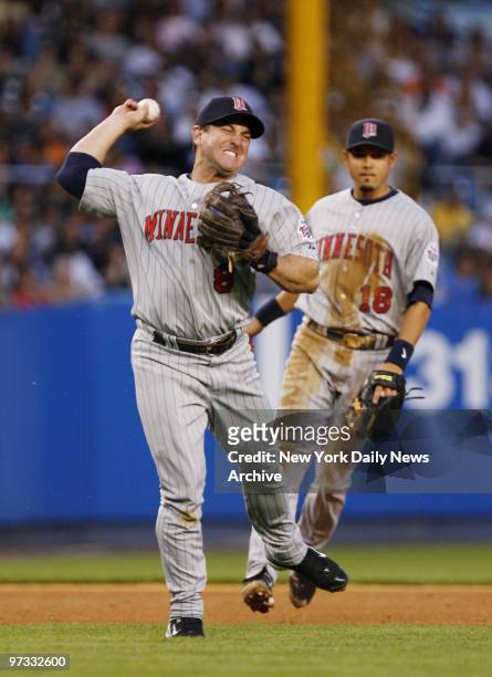 Minnesota Twins' third baseman Nick Punto rears back to fire the ball to first as he tries to throw out New York Yankees' Bobby Abreu in the fourth...