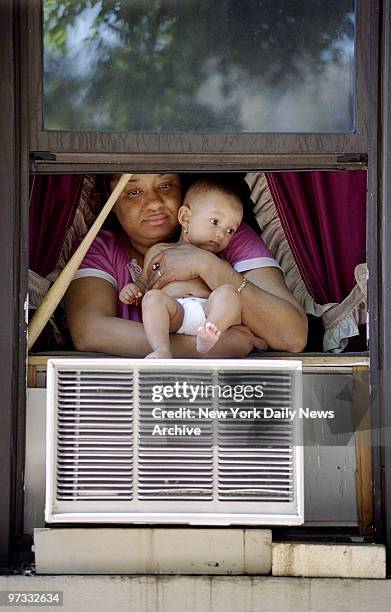 Oliva Cordero holds her 4-month-old granddaughter, Cinderilla, at the window for some air on W. 182th St., during power outage in Washington Heights.