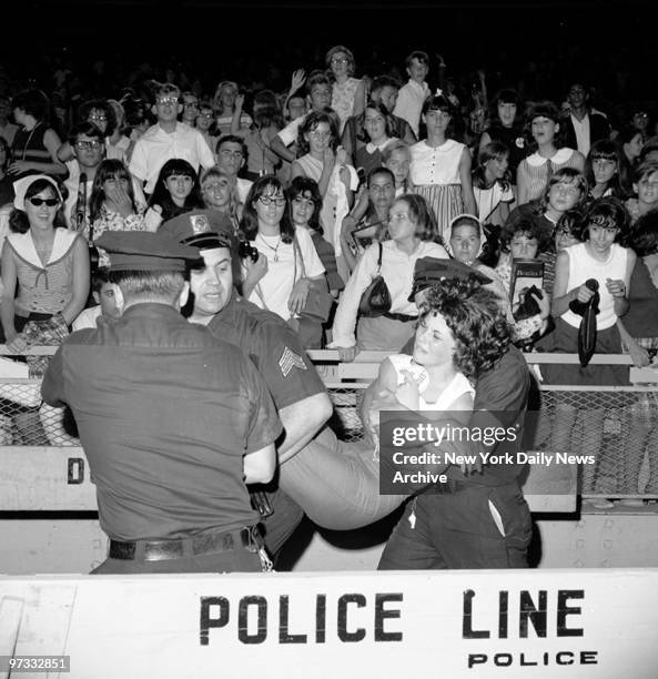 Teenager is carried off during the Beatles concert at Shea Stadium.