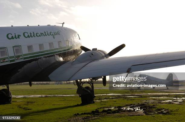 Main undercarriage, wing and PW R-1830-92 engine of a Douglas DC-3C with another DC-3 parked behind.