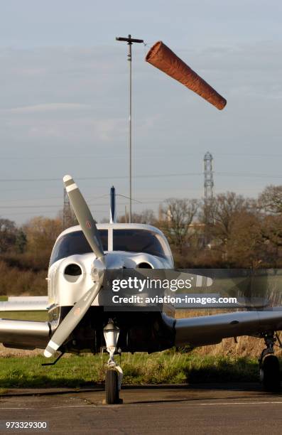 A Piper PA-28-181 Cherokee Archer 3 / III parked with the windsock behind.