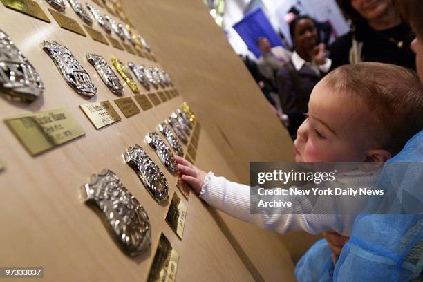 Ten-month-old Mariah Heffernan touches shield of Police Officer Jeff Herman, who died in the line of duty, at the New York City Police Museum in...