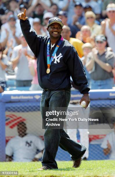 Olympic gold medalist Justin Gatlin of the U.S. Waves to the crowd as he walks onto the field to throw out the first pitch at a game between the New...