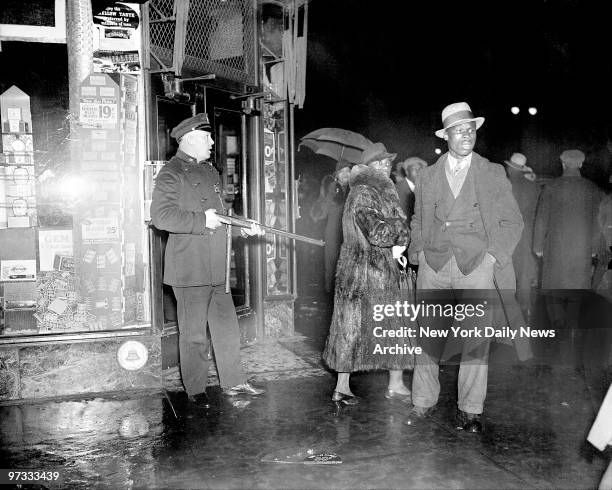 Ominously raising his weapon during rioting in Harlem, this policeman is guarding a drugstore at W. 125th St. And Seventh Ave. The riot on the night...