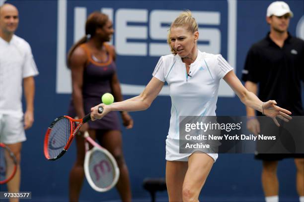 Tennis star Steffi Graf hits the ball as husband Andre Agassi, Serena Williams and Andy Roddick look on during Arthur Ashe Kids' Day at the USTA...