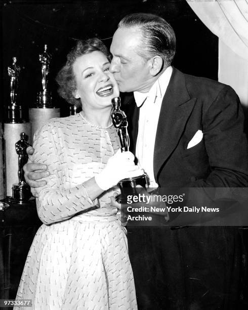 On stage at the International Threatre, Columbus Circle, seconds after the announcement in Hollywood. Shirley Booth receives a kiss and an Oscar from...