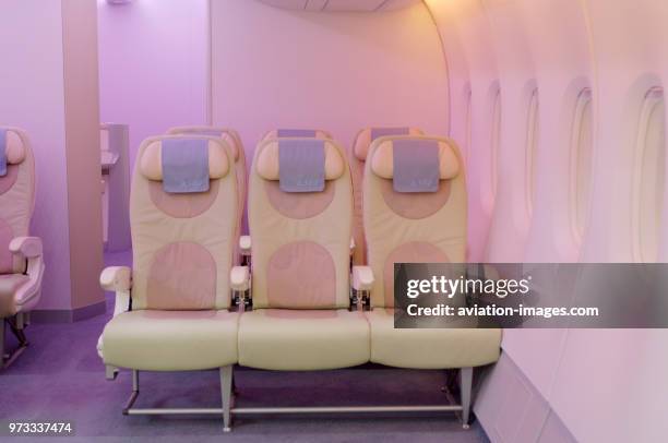 Seats in the A380 economy-class cabin mock-up with pink mood lighting on the Airbus exhibition stand.