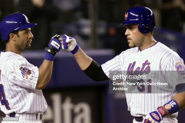 New York Mets' Mike Piazza is congratulated by teammate Jay Payton after hitting a solo home run in the seventh inning. The Mets beat the...