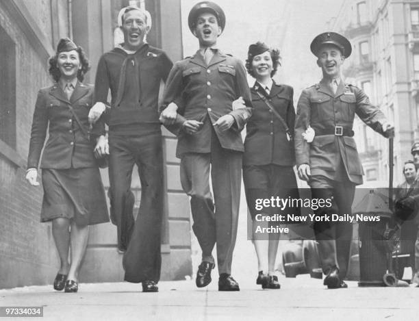 On V-E Day, members of the armed services stage an impromptu parade in front of City Defense Recreation Committee headquarters. Celebrating the...