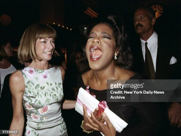 Vogue editor Anna Wintour looks on as Oprah Winfrey emotes at party at Balthazar promoting Vogue's October issue with Winfrey's picture on the cover.