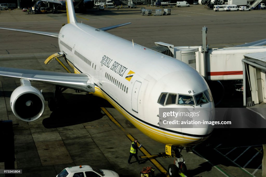 PW4056 engine intake and leading-edge of the wing of a Royal Brunei Airlines Boeing 767-300 parked at the gate at Terminal3 with rear cargo door open and jetway attached
