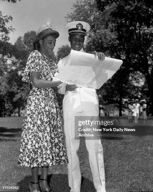 One of the proudest graduates, Ensign Wesley A. Brown of Washington, D.C., shows commission to his girl friend, Sylvia Johnson Hicks. He is the first...