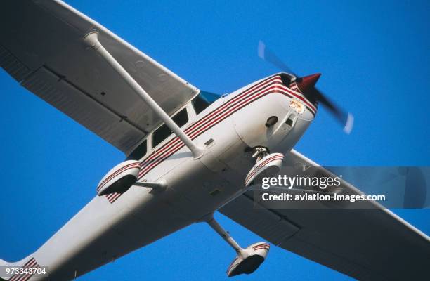 Generic Cessna 172N Skyhawk climbing out after take-off with undercarriage wheel spats and landing-lights on.