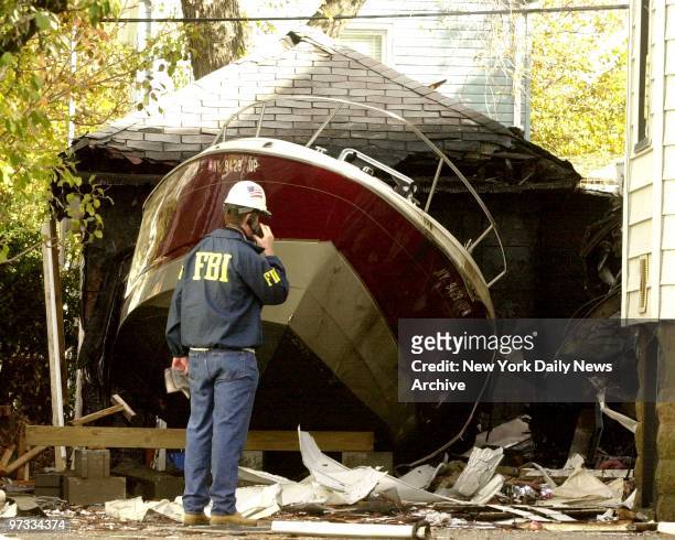 Domincan airliner flight 587 crashed in Rockaway after take-off from Kennedy Airport this morning. FBI investigator looks over boat that was hit with...