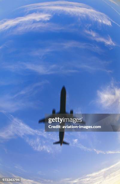 Airbus A321-200 on final-approach with clouds behind, motion-blurred image.