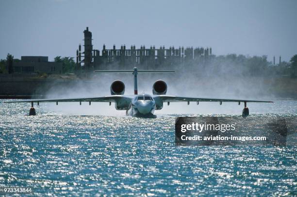 Beriev Be-200 water taxiing in a blue sea in the bay with sun glinting off the waves at Gidroaviasalon 2000.