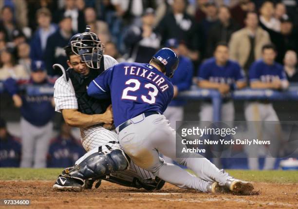 Texas Rangers' Mark Teixeira collides with New York Yankees' catcher Jorge Posada at the plate in the sixth inning at Yankee Stadium. Posada held...