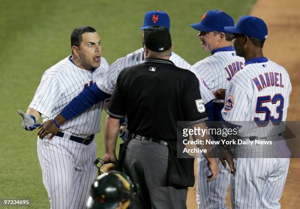 New York Mets' Paul Lo Duca argues a called strike with home plate umpire Marvin Hudson as Mets' manager Willie Randolph stands between them in the...