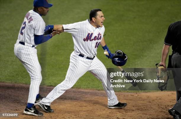 New York Mets' Paul Lo Duca argues a called strike with home plate umpire Marvin Hudson as he's held back by Mets' manager Willie Randolph in the...