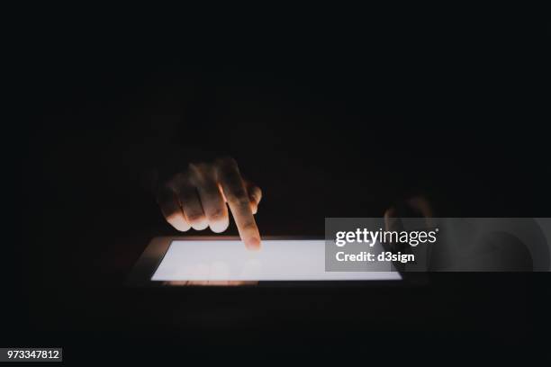 close up of woman's hands touching digital tablet screen in the dark - electronic organizer stock pictures, royalty-free photos & images