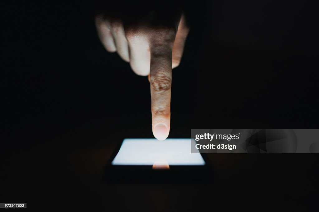 Close up of woman's hand using smartphone in the dark