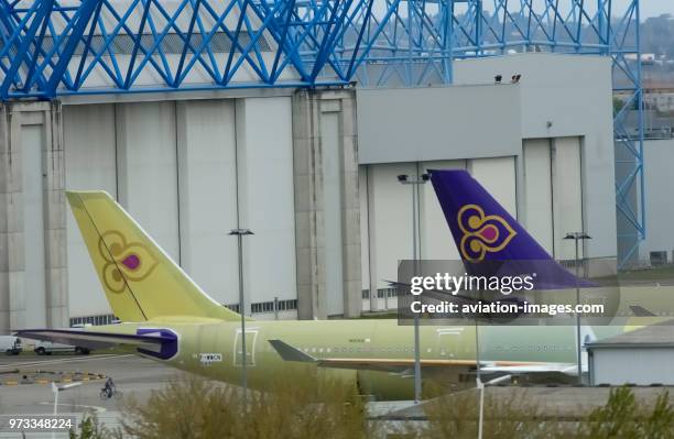 Two Thai Airways International Airbus A340-642 aircraft parked outside the Airbus Factory one in yellow primer livery before painting.