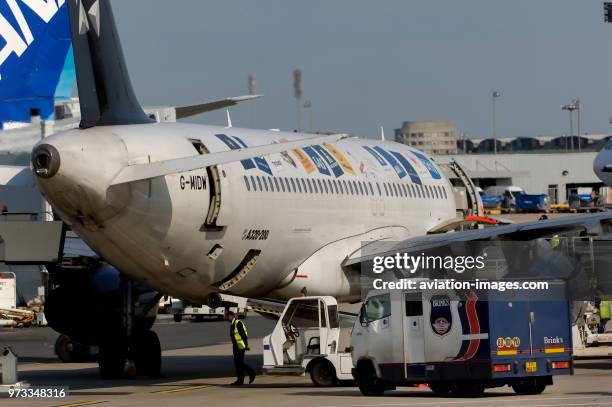 Brinks high security truck by A320 on turnaround with a Star Alliance livery and cargo and passenger doors open.