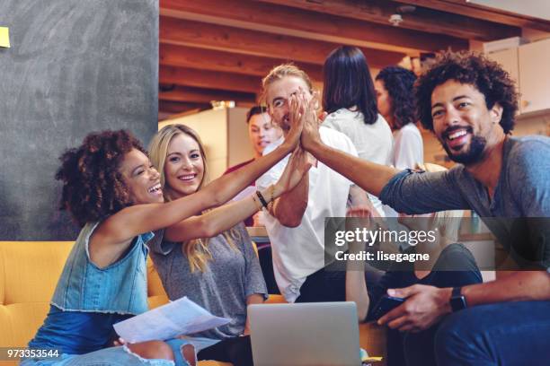 young entrepreneurs celebrating - place of work celebrate stock pictures, royalty-free photos & images