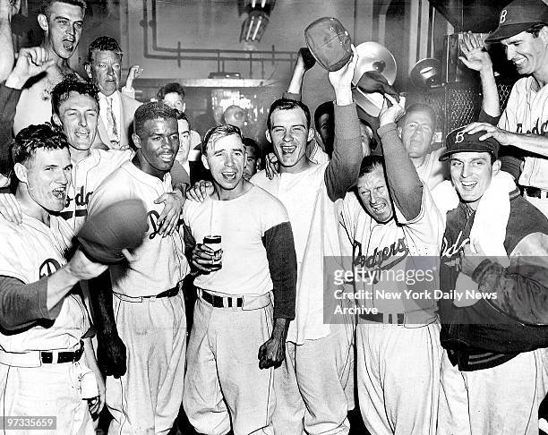 Dodgers celebrate in the clubhouse after defeating the Philadelphia Phillies in 14 innings to tie the NY Giants for first place in the National...