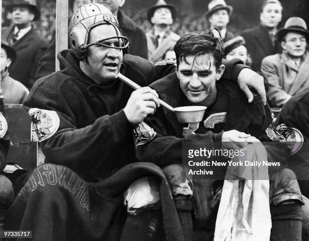 Washington Redskins' "Slinging" Sammy Baugh is helped to a drink of water by Ernie Pinckert during game against the New York Giants at the Polo...
