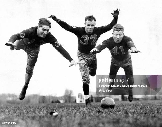 Washington Redskins Ed Justice, Bob McChesney, and Henry Krause lunge for the football during practice.