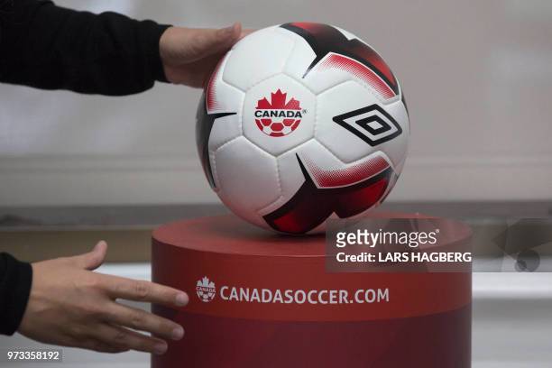 An employee adjusts a soccer ball at Soccer Canada Headquarters in Ottawa, Ontario on June 13 as Canada will co-host the 2026 World Cup with Mexico...