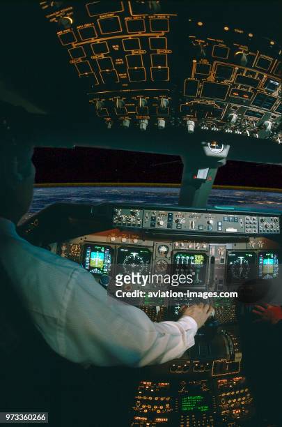 Pilot with hand on the throttle-levers in the Thai Airways International Boeing 747-400 cockpit simulator at high-altitude over Egypt heading north...