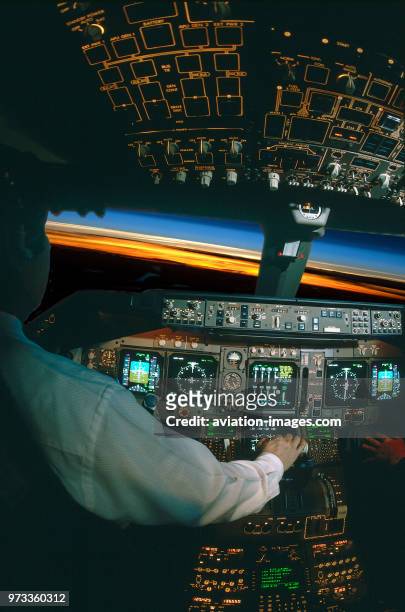 Pilot with hand on the throttle-levers in the Thai Airways International Boeing 747-400 cockpit simulator at high-altitude with curvature of the...