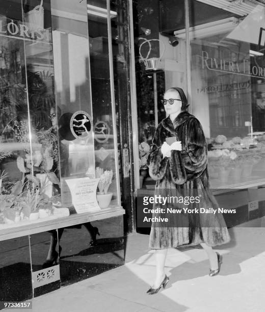 Wearing dark glasses and carrying prayer book, actress Grace Kelly walks unnoticed along Madison Ave. At 81st St. After attending early Palm Sunday...