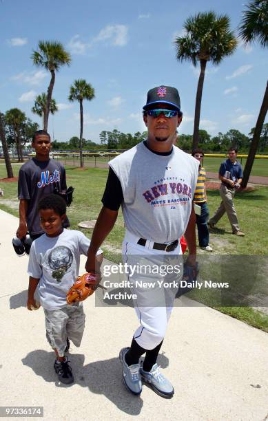 New York Mets' pitcher Pedro Martinez walks out to a practice field, holding the hand of a young relative, at Tradition Field in Port St. Lucie, Fla....