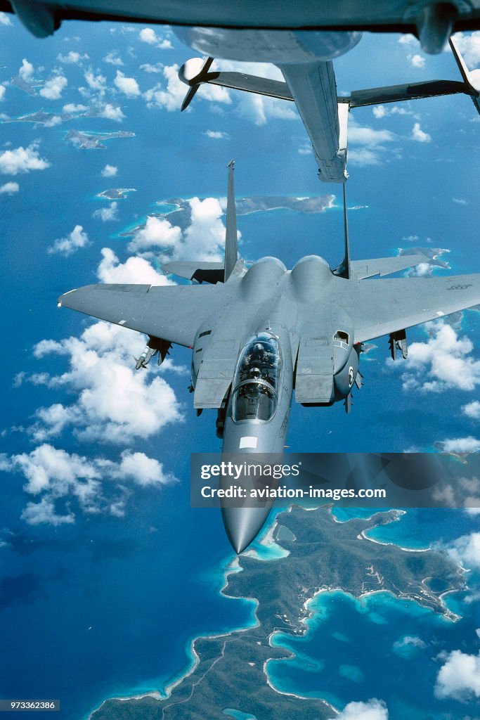 USAF Boeing F-15E Strike Eagle of 335 Sqn approaching a McDonnell Douglas KC-10A aerial-refuelling tanker over the Caribbean Sea tropical islands