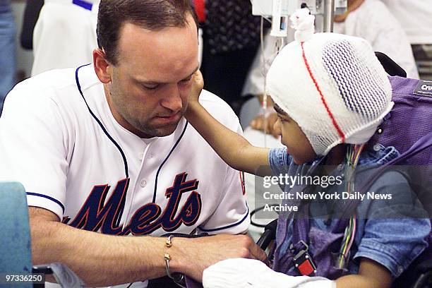 New York Mets' pitcher Rick Reed shares a touching moment with Zoe Willard while visiting children at NYU Medical Center's Rusk Institute of...