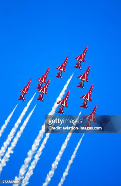 Red Arrows BAE Hawks flying in formation with white smoke in the flying-display at the 1996 Farnborough Air Show.