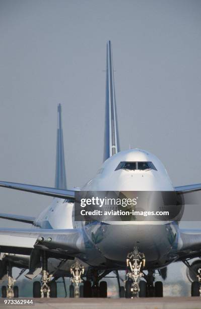 Boeing 747s queue on taxiway.