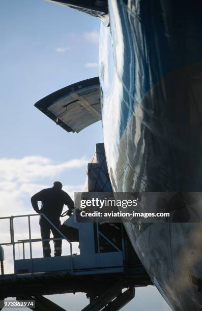 Man on a low-loader with cargo being loaded onto a Korean Air Lines Boeing 747-200F.
