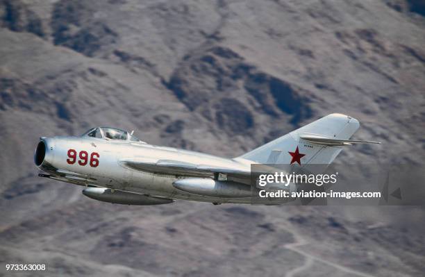 Soviet Union - Air Force Mikoyan MiG-15 Fagot climbing out after take-off with mountains behind.